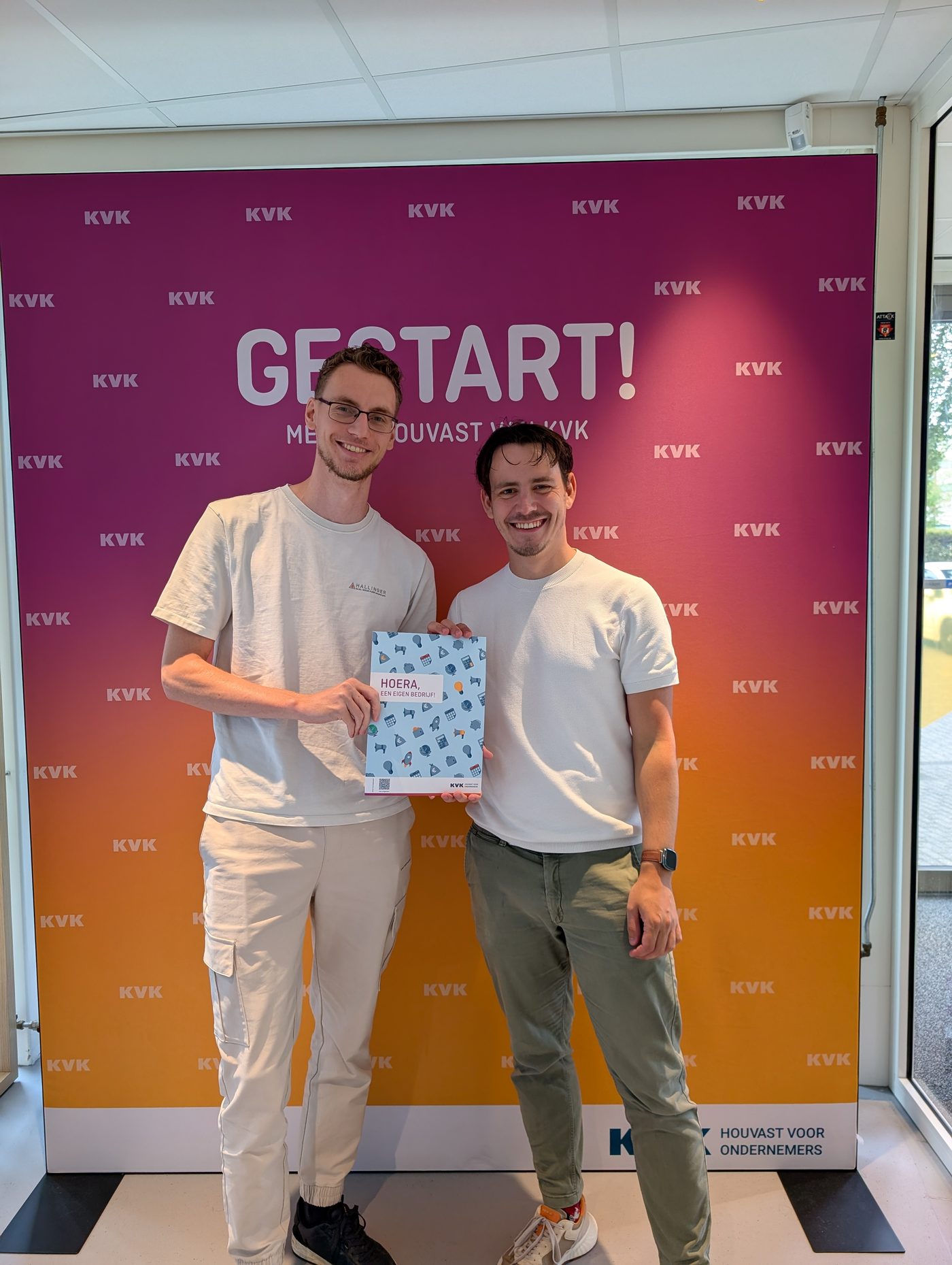 The two founders of Guubra Games at the Dutch Chamber of Commerce on registration day, holding the welcome folder.